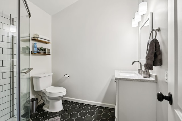 bathroom featuring baseboards, toilet, vanity, and a tile shower