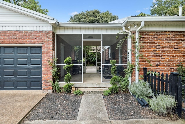 property entrance with brick siding, concrete driveway, and fence