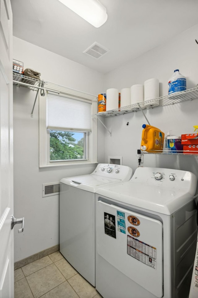 laundry area with light tile patterned floors, visible vents, baseboards, laundry area, and washing machine and dryer