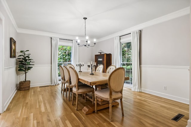 dining room featuring a wealth of natural light, visible vents, crown molding, and light wood-type flooring