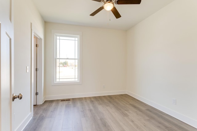 empty room featuring visible vents, baseboards, a ceiling fan, and light wood finished floors