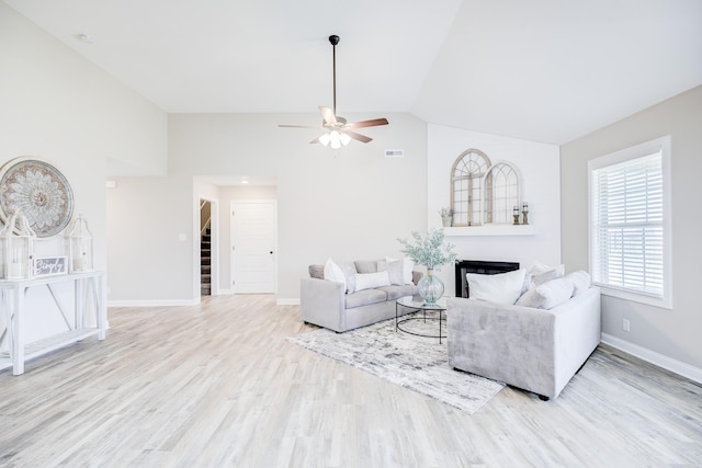 living area featuring visible vents, baseboards, stairway, lofted ceiling, and wood finished floors