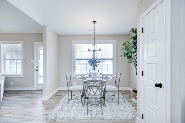 dining space featuring light wood finished floors, a healthy amount of sunlight, and baseboards