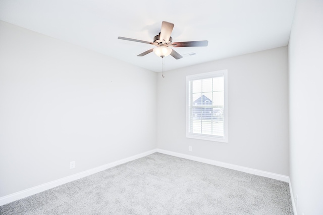 carpeted empty room featuring visible vents, baseboards, and ceiling fan