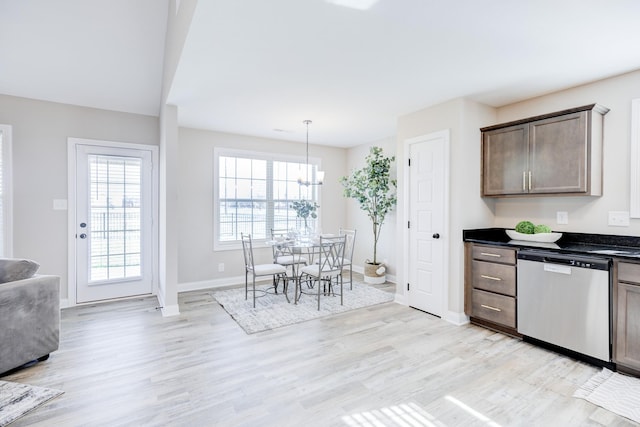 kitchen with dark brown cabinets, stainless steel dishwasher, dark countertops, and light wood-style flooring