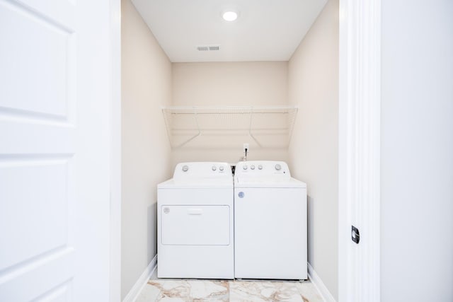 clothes washing area featuring washer and dryer, baseboards, marble finish floor, and laundry area