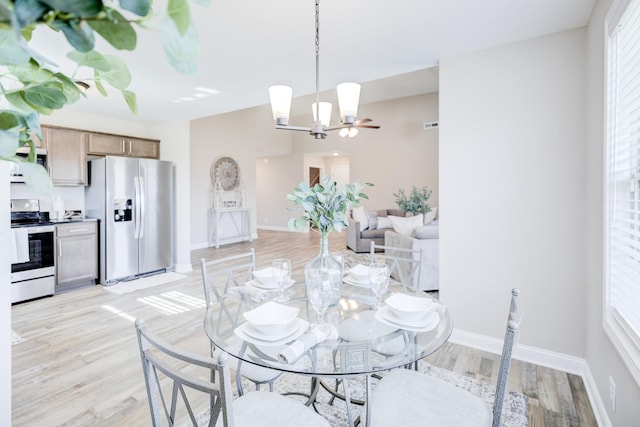 dining area with a notable chandelier, light wood-style floors, and baseboards