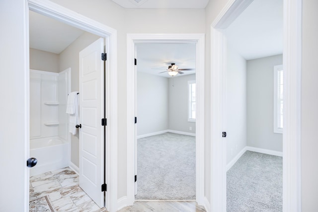 interior space featuring baseboards, marble finish floor, a tub to relax in, and a ceiling fan