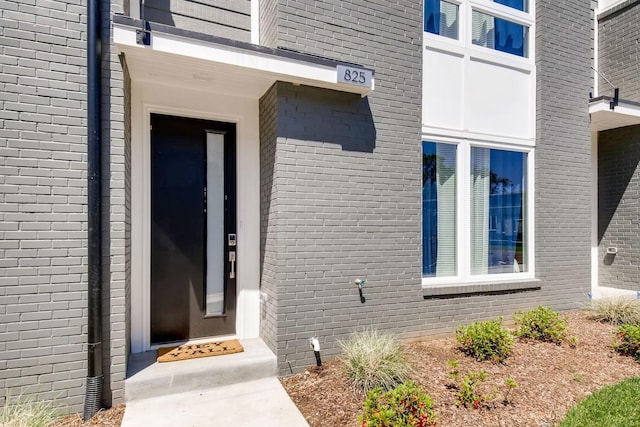 doorway to property featuring brick siding