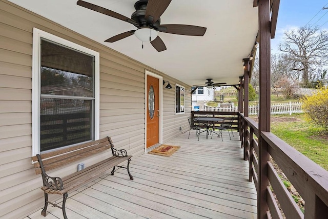 deck with outdoor dining area, ceiling fan, and fence