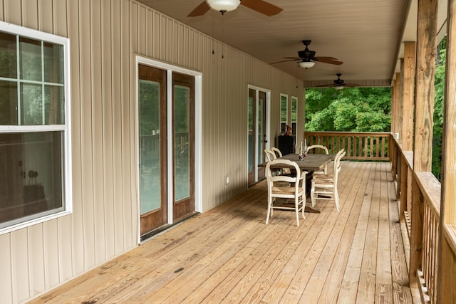 wooden deck featuring outdoor dining space and ceiling fan