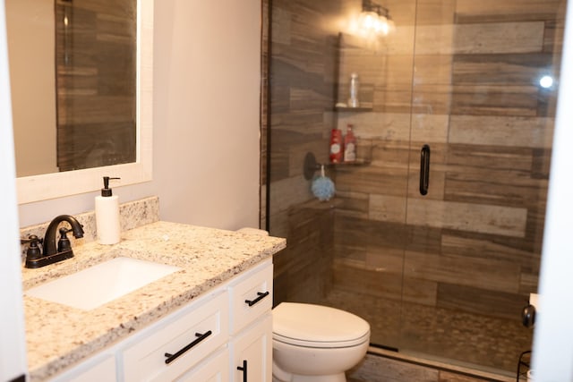 full bathroom with a stall shower, toilet, and vanity