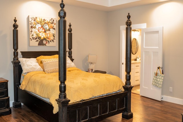 bedroom with dark wood finished floors, baseboards, and ensuite bathroom