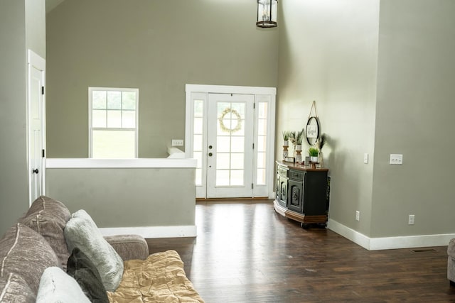 entrance foyer with baseboards, a high ceiling, and wood finished floors