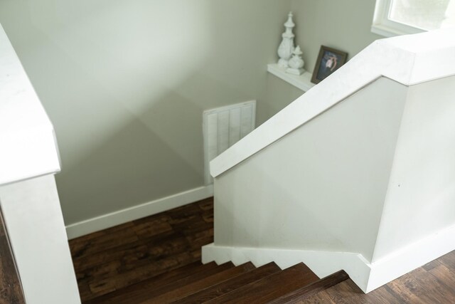 stairway featuring wood finished floors and baseboards