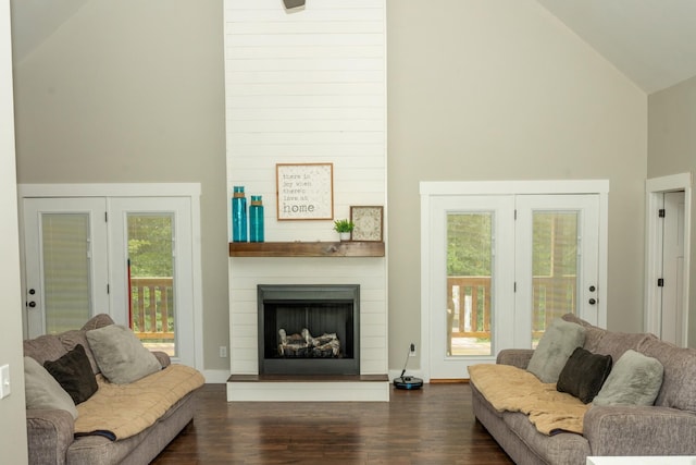 living area with a large fireplace, high vaulted ceiling, and dark wood-style floors