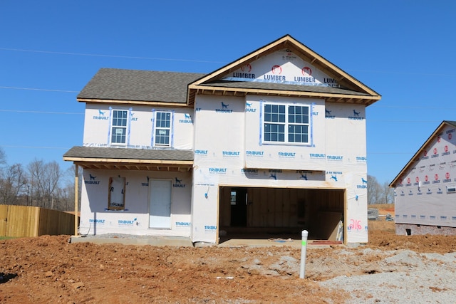 property in mid-construction with an attached garage, fence, and roof with shingles