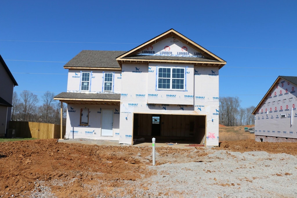 property in mid-construction with an attached garage and a shingled roof