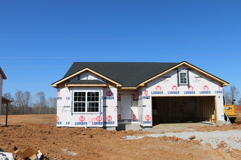 property in mid-construction featuring an attached garage and a shingled roof