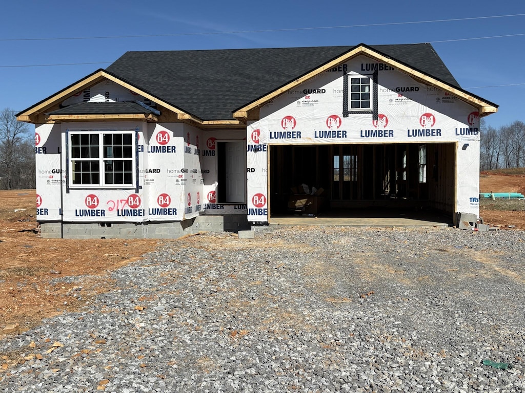 property under construction with a garage, driveway, and a shingled roof