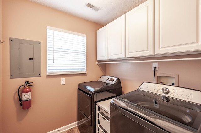 washroom featuring visible vents, electric panel, washer and dryer, cabinet space, and baseboards