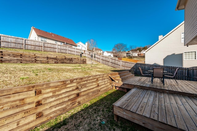 view of yard with a deck, outdoor dining area, a fenced backyard, and a residential view