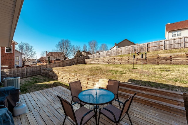 wooden terrace with central air condition unit, a yard, and a fenced backyard