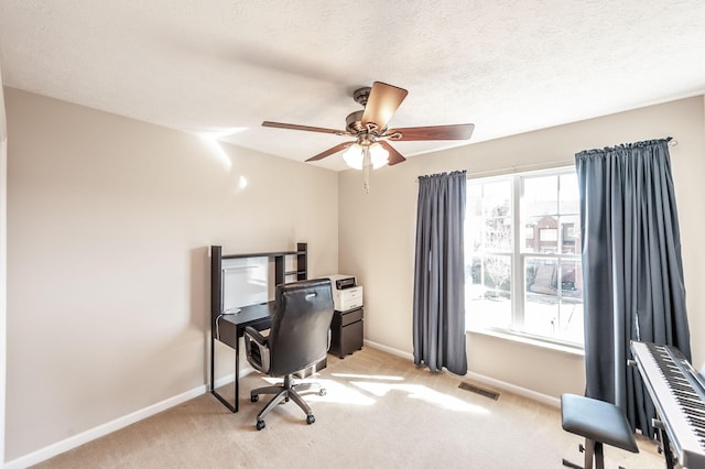 office space featuring visible vents, light carpet, a textured ceiling, and baseboards