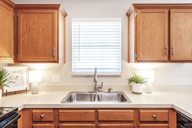 kitchen with black electric range, brown cabinets, light countertops, and a sink