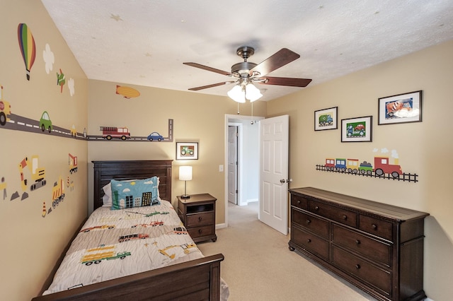 bedroom with baseboards, light colored carpet, a ceiling fan, and a textured ceiling