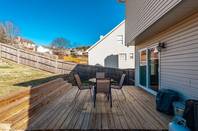 wooden terrace featuring a lawn, area for grilling, a residential view, outdoor dining area, and fence private yard