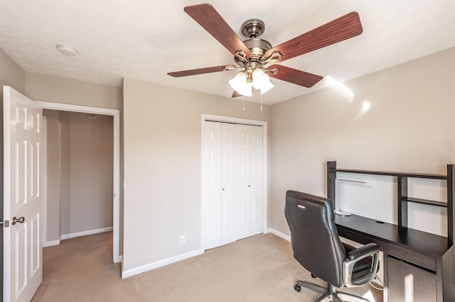 office with baseboards, light carpet, a textured ceiling, and a ceiling fan