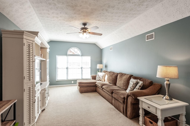 living room with visible vents, light colored carpet, a ceiling fan, and vaulted ceiling