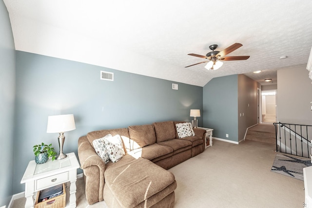 living room with visible vents, baseboards, light colored carpet, and a textured ceiling