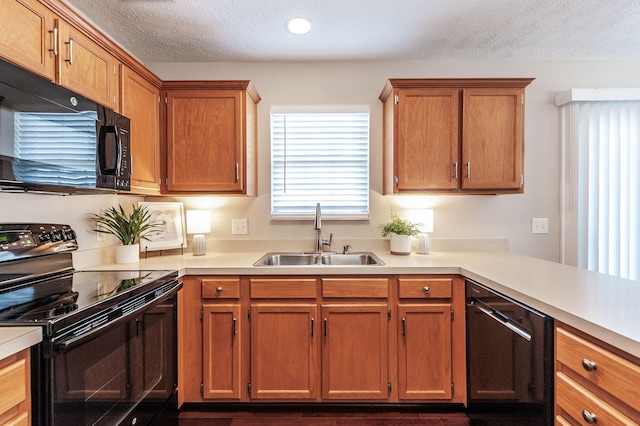 kitchen featuring a sink, a textured ceiling, black appliances, and light countertops