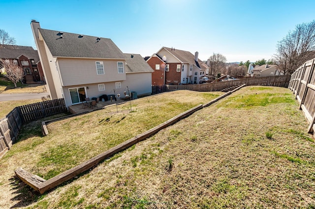 view of yard with a residential view, a fenced backyard, and a patio area