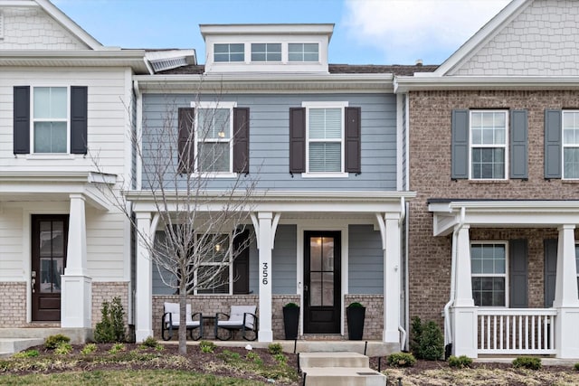 townhome / multi-family property featuring brick siding and a porch