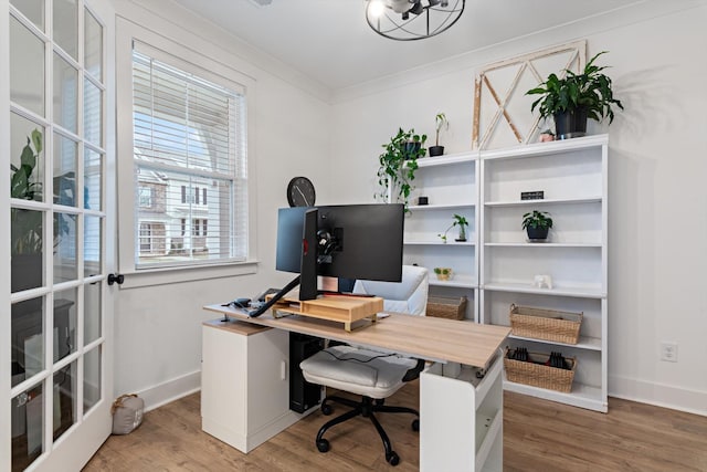 office area with baseboards, wood finished floors, and ornamental molding