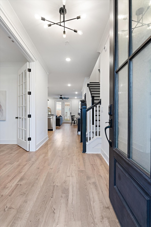 entryway featuring ceiling fan, baseboards, wood finished floors, and stairs