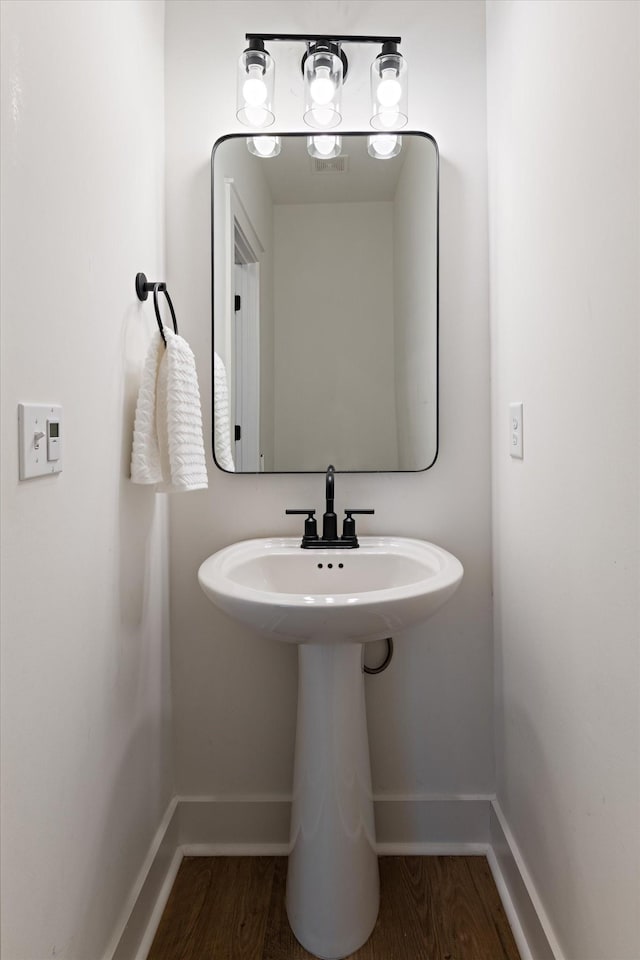 bathroom with baseboards and wood finished floors