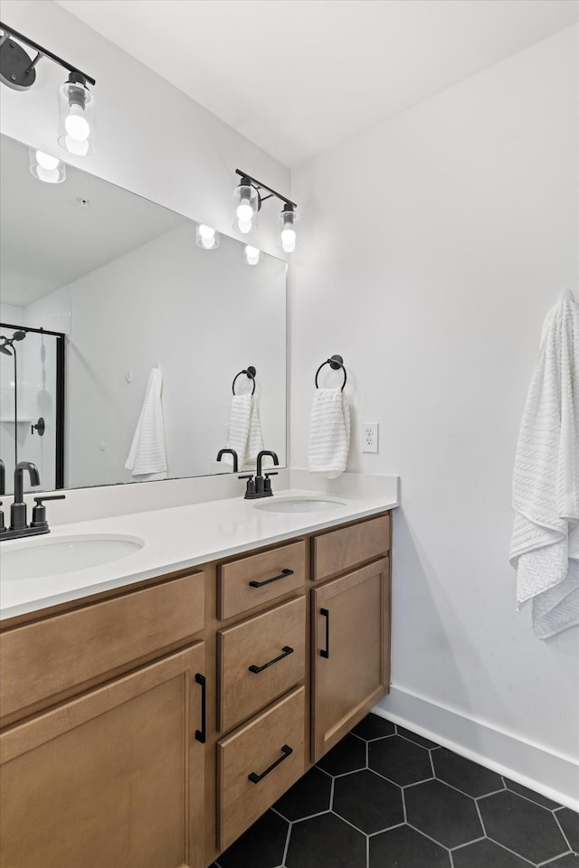 full bath with double vanity, a shower with door, tile patterned floors, and a sink