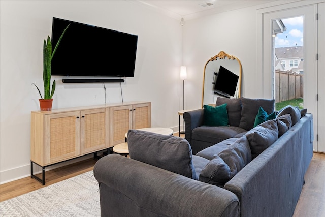 living area with visible vents, baseboards, and wood finished floors