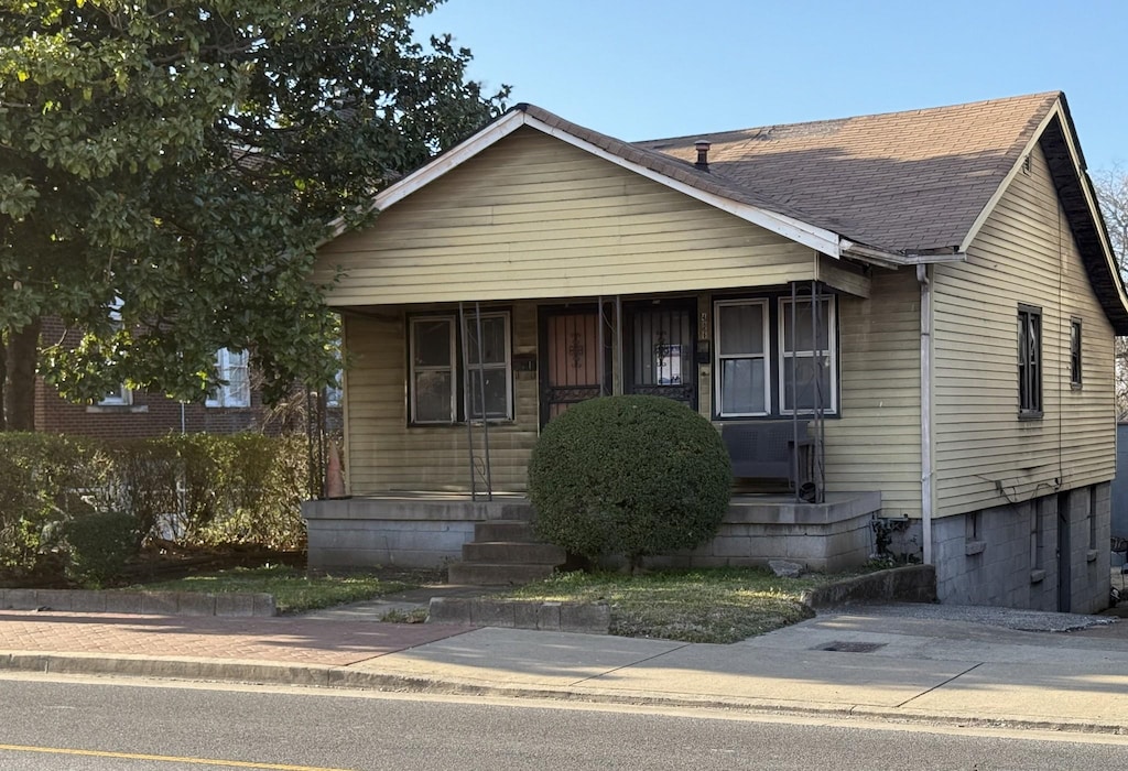 bungalow-style home featuring roof with shingles and covered porch