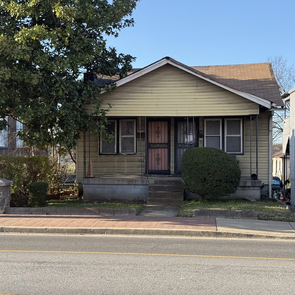 bungalow-style home with a porch and a shingled roof