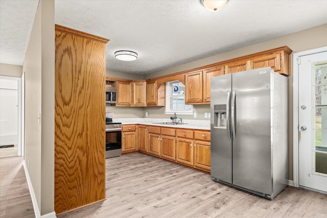 11216 Clay County Hwy, Moss, TN 38575 - kitchen with a sink, light countertops, light wood-style flooring, and stainless steel appliances