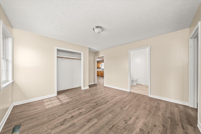 11216 Clay County Hwy, Moss, TN 38575 - unfurnished bedroom with a closet, multiple windows, baseboards, and wood finished floors