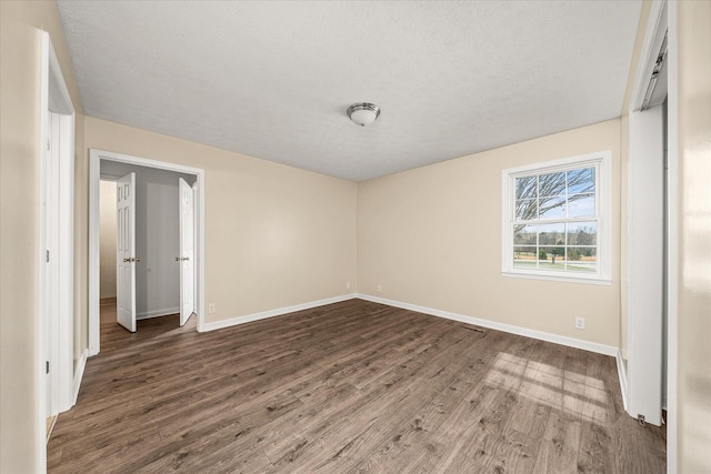 11216 Clay County Hwy, Moss, TN 38575 - unfurnished bedroom featuring baseboards, a textured ceiling, and wood finished floors