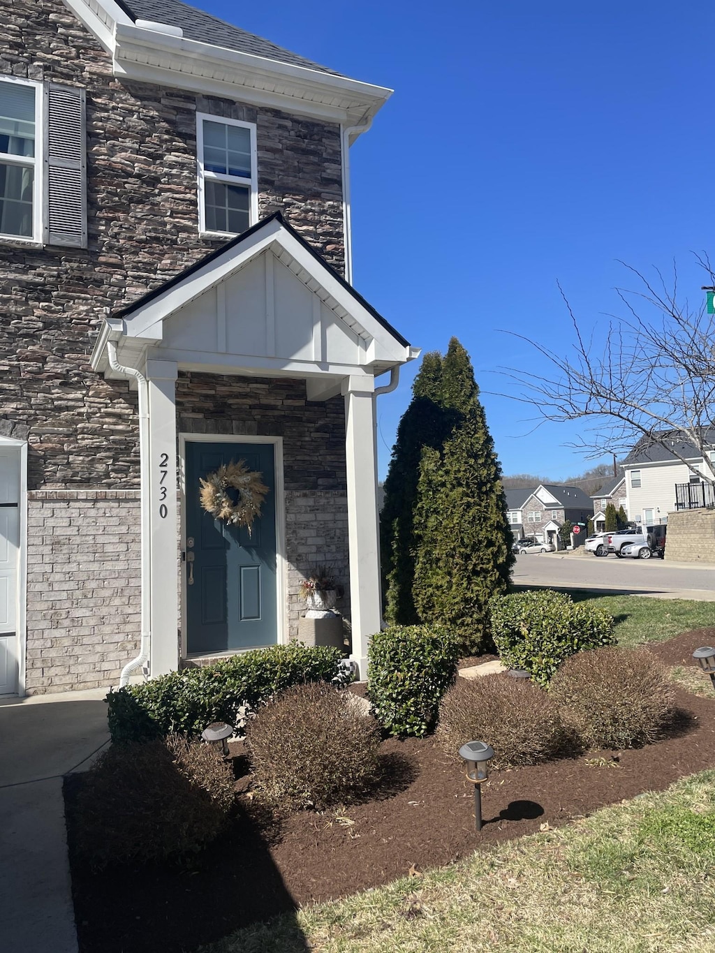 view of exterior entry featuring board and batten siding and stone siding