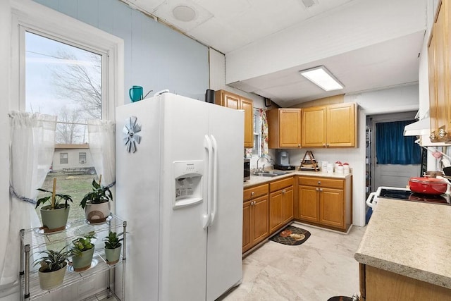 kitchen featuring light countertops, lofted ceiling, marble finish floor, white appliances, and a sink