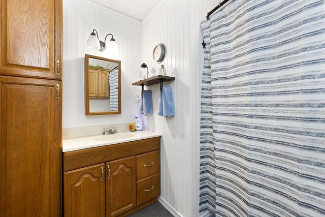 bathroom with curtained shower, vanity, and ornamental molding